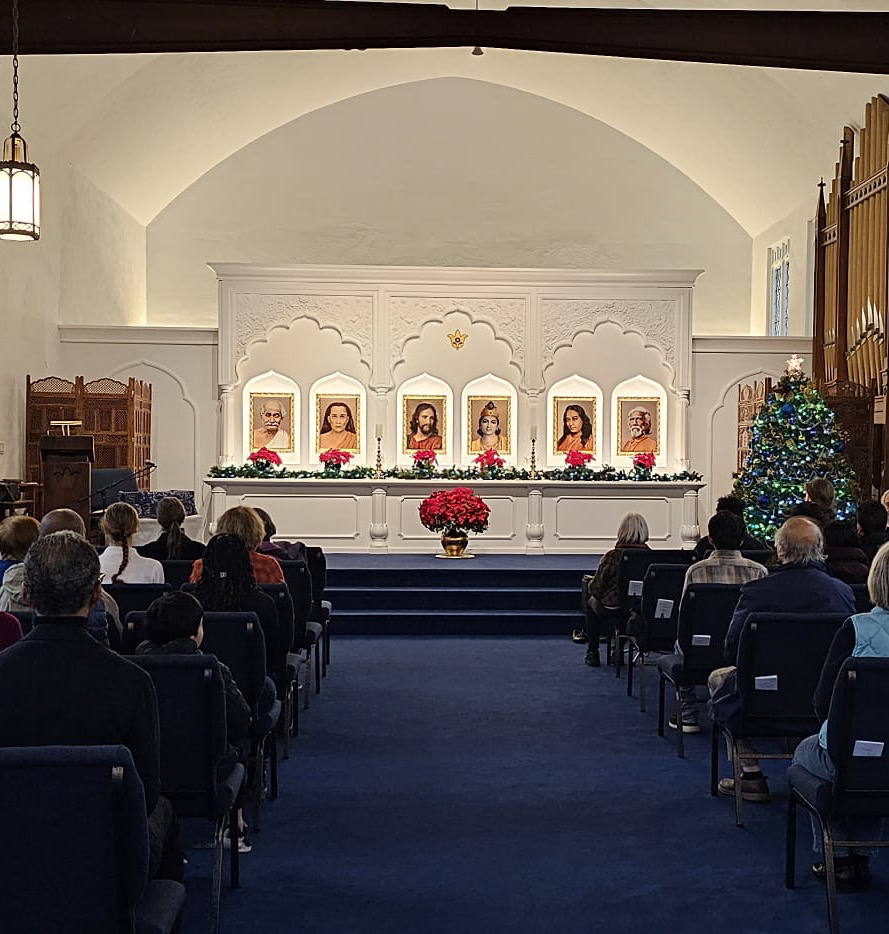 The sanctuary of the Boston Center of SRF with devotees meditating and the altar in front.
